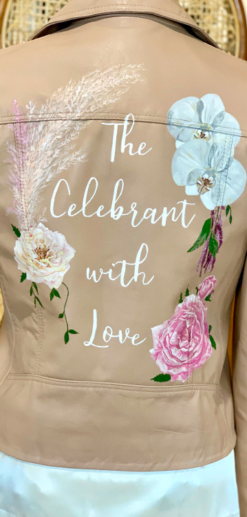 Tan leather jacket with 'The Celebrant with Love' words and florals painted on the back.