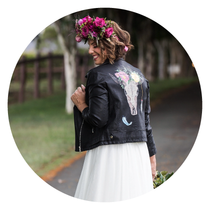 Image in circle of girl with black leather jacket and flowers in her hair.